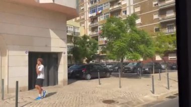 Lizbon 'da caddenin karşısındaki hareket halindeki tramvayın penceresinden bak.