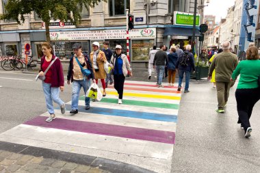 Brüksel 'de gökkuşağı zebrasının çapraz işaretlerini geçen yayalar