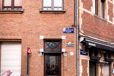 Brüksel 'de bir gay barının girişinin yanındaki gökkuşağı arka plan tabelasında Şirin çizgi filmi.