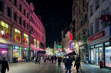 İnsanlar geceleri Brüksel şehir merkezinde yürüyor.