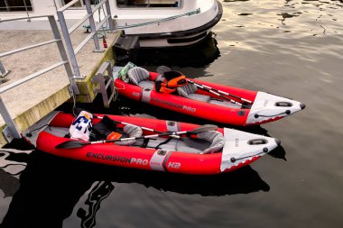 Belçika 'nın Dinant kentindeki Meuse nehrinin kıyısına yanaşmış iki kırmızı şişme tekne.