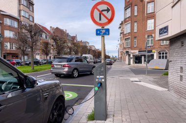 Brüksel 'de yol kenarında park halindeyken şarj olan elektrikli bir araba.