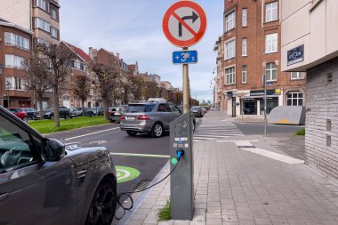 Brüksel 'de yol kenarında park halindeyken şarj olan elektrikli bir araba.