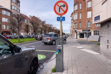Brüksel 'de yol kenarında park halindeyken şarj olan elektrikli bir araba.