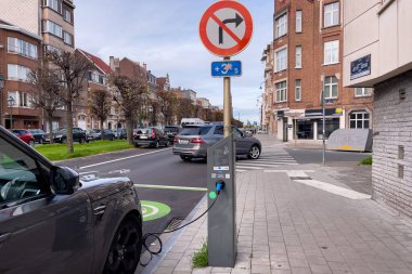 Brüksel 'de yol kenarında park halindeyken şarj olan elektrikli bir araba.
