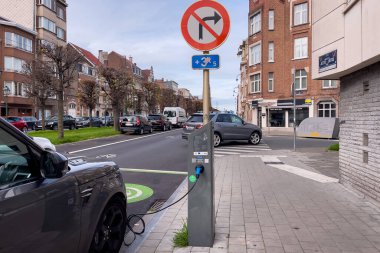 Brüksel 'de yol kenarında park halindeyken şarj olan elektrikli bir araba.
