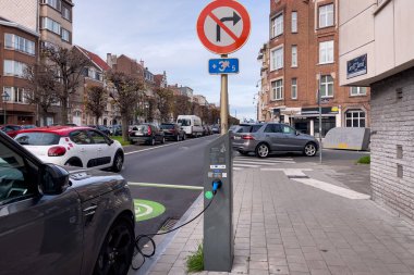 Brüksel 'de yol kenarında park halindeyken şarj olan elektrikli bir araba.