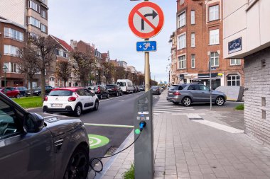 Brüksel 'de yol kenarında park halindeyken şarj olan elektrikli bir araba.