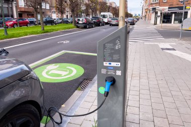 Brüksel 'de yol kenarında park halindeyken şarj olan elektrikli bir araba.