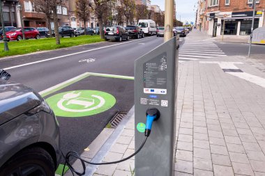Brüksel 'de yol kenarında park halindeyken şarj olan elektrikli bir araba.