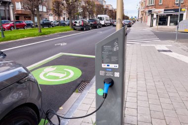 Brüksel 'de yol kenarında park halindeyken şarj olan elektrikli bir araba.