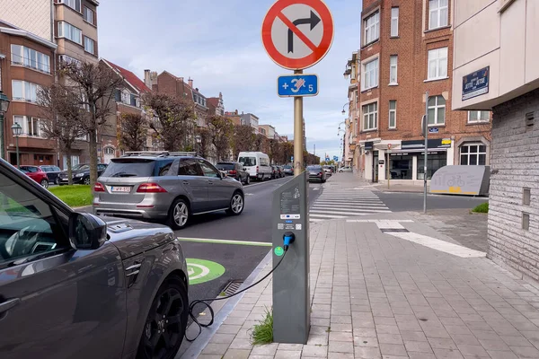 Brüksel 'de yol kenarında park halindeyken şarj olan elektrikli bir araba.