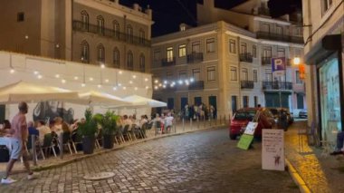 Lizbon, Portekiz caddesinde geceleri yürüyen bir kalabalık.