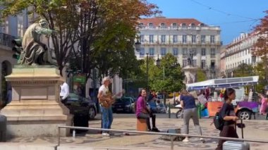 Lizbon 'daki Chiado Meydanı' nda takılan insanlar.