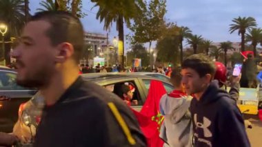 FIFA Dünya Kupası Katar 2022 'de milli takımının zaferinden sonra yolları kapatan bayrak sallayan mutlu Faslı taraftarlar