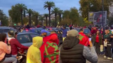 FIFA Dünya Kupası Katar 2022 'de milli takımının zaferinden sonra yolları kapatan bayrak sallayan mutlu Faslı taraftarlar