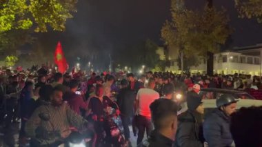 FIFA Dünya Kupası Katar 2022 'de milli takımının zaferinden sonra yolları kapatan bayrak sallayan mutlu Faslı taraftarlar
