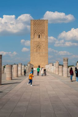 Rabat, Fas 'taki Hasan Kulesi' nin yanındaki ortaçağ sütunlarında yürüyen insanlar.