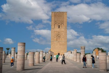Rabat, Fas 'taki Hasan Kulesi' nin yanındaki ortaçağ sütunlarında yürüyen insanlar.
