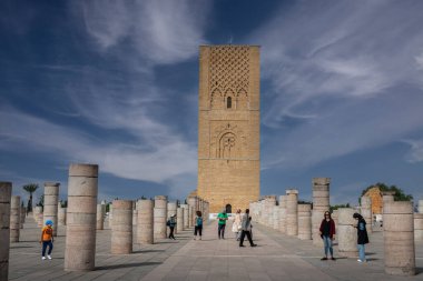 Rabat, Fas 'taki Hasan Kulesi' nin yanındaki ortaçağ sütunlarında yürüyen insanlar.