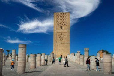 Rabat, Fas 'taki Hasan Kulesi' nin yanındaki ortaçağ sütunlarında yürüyen insanlar.
