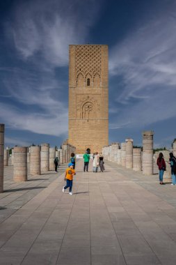 Rabat, Fas 'taki Hasan Kulesi' nin yanındaki ortaçağ sütunlarında yürüyen insanlar.