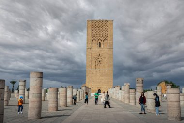 Rabat, Fas 'taki Hasan Kulesi' nin yanındaki ortaçağ sütunlarında yürüyen insanlar.