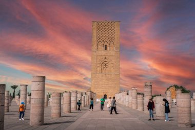 Rabat, Fas 'taki Hasan Kulesi' nin yanındaki ortaçağ sütunlarında yürüyen insanlar.
