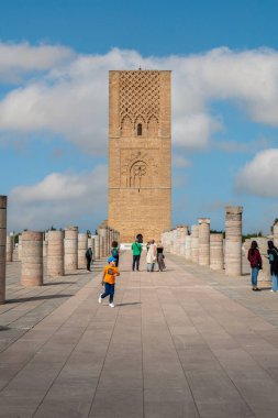 Rabat, Fas 'taki Hasan Kulesi' nin yanındaki ortaçağ sütunlarında yürüyen insanlar.