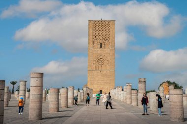 Rabat, Fas 'taki Hasan Kulesi' nin yanındaki ortaçağ sütunlarında yürüyen insanlar.