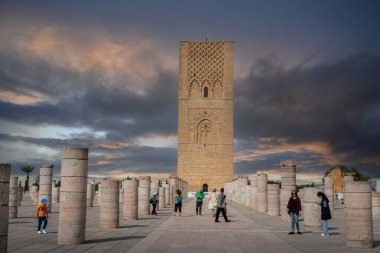 Rabat, Fas 'taki Hasan Kulesi' nin yanındaki ortaçağ sütunlarında yürüyen insanlar.