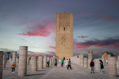 Rabat, Fas 'taki Hasan Kulesi' nin yanındaki ortaçağ sütunlarında yürüyen insanlar.