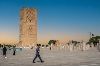 Rabat, Fas 'taki Hasan Kulesi' nin yanındaki ortaçağ sütunlarında yürüyen insanlar.