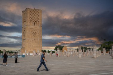 Rabat, Fas 'taki Hasan Kulesi' nin yanındaki ortaçağ sütunlarında yürüyen insanlar.