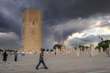 Rabat, Fas 'taki Hasan Kulesi' nin yanındaki ortaçağ sütunlarında yürüyen insanlar.