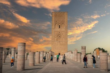 Rabat, Fas 'taki Hasan Kulesi' nin yanındaki ortaçağ sütunlarında yürüyen insanlar.