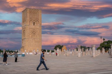 Rabat, Fas 'taki Hasan Kulesi' nin yanındaki ortaçağ sütunlarında yürüyen insanlar.