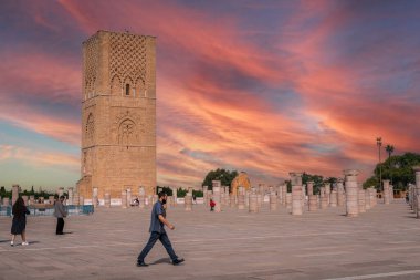 Rabat, Fas 'taki Hasan Kulesi' nin yanındaki ortaçağ sütunlarında yürüyen insanlar.