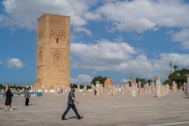 Rabat, Fas 'taki Hasan Kulesi' nin yanındaki ortaçağ sütunlarında yürüyen insanlar.