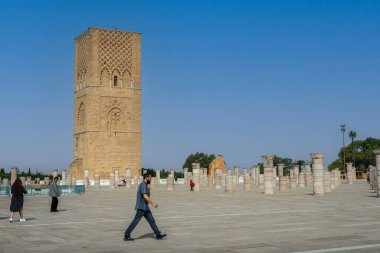 Rabat, Fas 'taki Hasan Kulesi' nin yanındaki ortaçağ sütunlarında yürüyen insanlar.