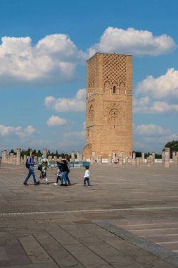 Rabat, Fas 'taki Hasan Kulesi' nin yanındaki ortaçağ sütunlarında yürüyen insanlar.