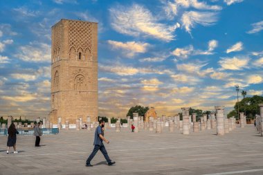 Rabat, Fas 'taki Hasan Kulesi' nin yanındaki ortaçağ sütunlarında yürüyen insanlar.