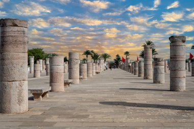 Rabat, Fas 'taki Hasan Kulesi' nin yanındaki ortaçağ sütunlarında yürüyen insanlar.