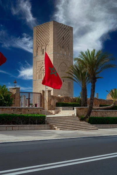 stock image Moroccan flag fluttering and the Hassan tower in the background in Rabat