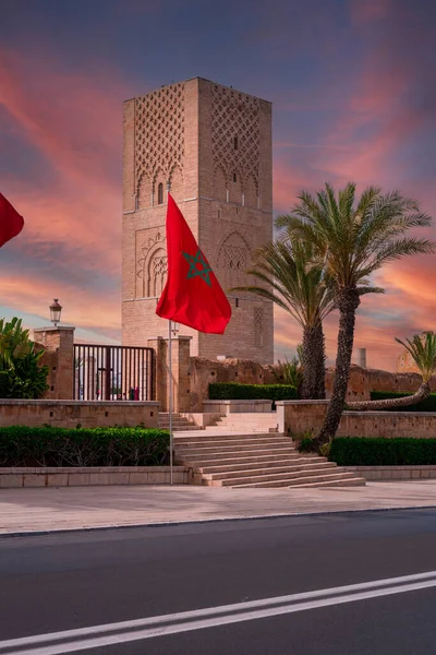 stock image Moroccan flag fluttering and the Hassan tower in the background in Rabat