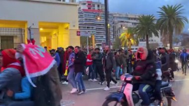 FIFA Dünya Kupası Katar 2022 'de milli takımının zaferinden sonra yolları kapatan bayrak sallayan mutlu Faslı taraftarlar