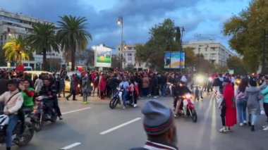 FIFA Dünya Kupası Katar 2022 'de milli takımının zaferinden sonra yolları kapatan bayrak sallayan mutlu Faslı taraftarlar