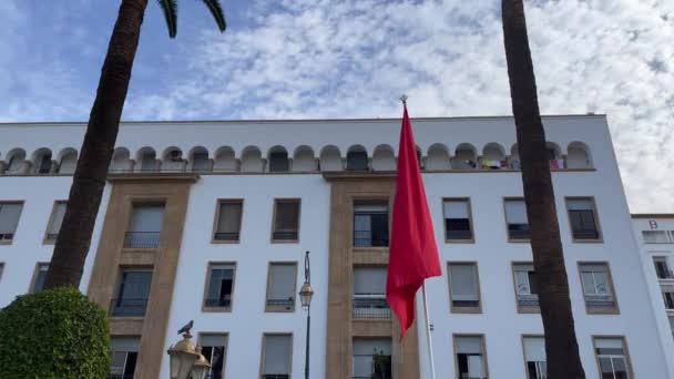 Μαροκινή Σημαία Κυματίζει Ένα Όμορφο Κτίριο Στο Βάθος — Αρχείο Βίντεο