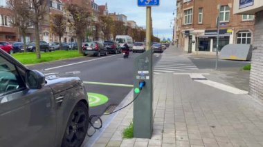 Brüksel 'de yol kenarında park halindeyken şarj olan elektrikli bir araba.