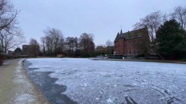Belçika, Zaventem 'deki Brasserie Mariadal binasının yanındaki buzlu gölet.